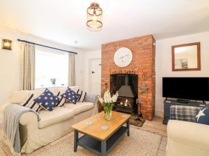 a living room with a couch and a fireplace at Shepherds Cottage in Dulverton