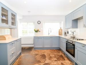 a kitchen with blue cabinets and a sink at Shepherds Cottage in Dulverton