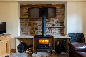 a fireplace in a living room with a stove at Chapel Beck, Millthrop in Sedbergh