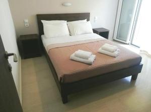 a bedroom with a bed with two towels on it at Hotel Thisvi in Stalís