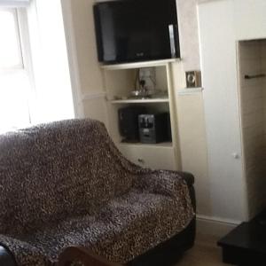 een woonkamer met een bank en een flatscreen-tv bij Noreen Seans in Carndonagh