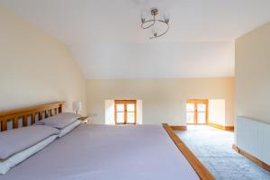 a large white bedroom with a large bed at Chapel Beck, Millthrop in Sedbergh
