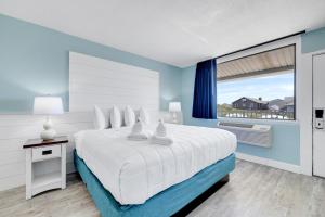 a bedroom with a large bed and a large window at John Yancey Oceanfront Inn in Kill Devil Hills