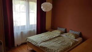 a bedroom with a bed with a window and a lamp at Apartmány Liptov MACO in Liptovský Mikuláš