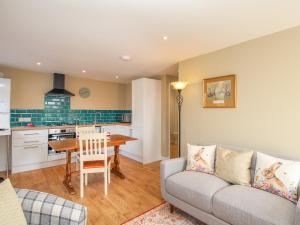 a living room with a couch and a table at Roundham Cottage in West Bay