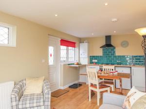 a kitchen and living room with a table and chairs at Roundham Cottage in West Bay +7 photos