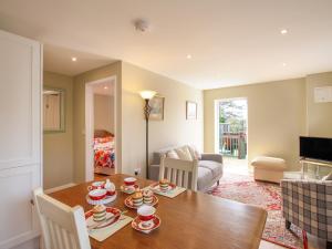 a living room with a table and a couch at Roundham Cottage in West Bay