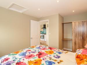 a bedroom with a bed with a floral bedspread at Roundham Cottage in West Bay