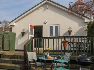 a patio with chairs and a table on a balcony at Roundham Cottage in West Bay