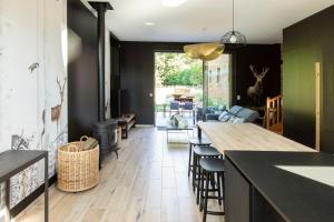 cocina con mesa y sillas y sala de estar. en Aux Bois Dorés de la Ferme de sorval, animaux de la ferme, fitness, en Selvigny