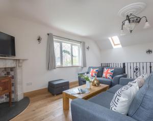 Una sala de estar con un sofá azul y una chimenea. en Fairholme, en Port Isaac