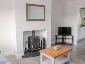 a living room with a wood stove and a tv at C64 Cahermore Holiday Village in Enniscrone