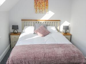 een slaapkamer met een groot bed met 2 nachtkastjes bij C64 Cahermore Holiday Village in Enniscrone