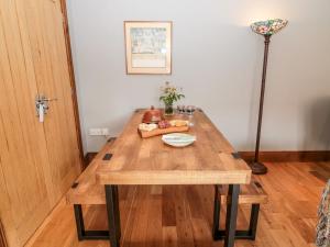 a wooden table with a plate of food on it at Sarah's Cottage in Morpeth