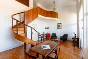 a living room with a wooden staircase and a table at Grande Hotel de Ouro Preto - 80 ANOS in Ouro Preto