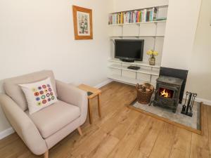 a living room with a chair and a fireplace at The Wash House in Banbury