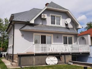 Casa blanca con porche y balcón en Blue House en Győrzámoly