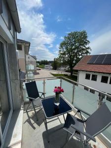 patio con mesa y sillas en el balcón en Traumhafte neue Dachterrassenwohnung am Soyener See, en Soyen