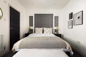 a bedroom with a large bed and two night stands at The Battersea Secret - Trendy 3BDR Flat with Patio in London