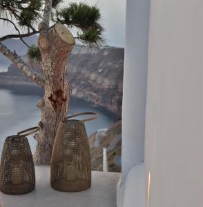 two bells sitting on a ledge next to a tree at Nelya Suites in Megalokhori