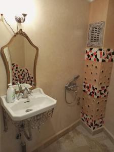 a bathroom with a sink and a mirror and a shower at RIAD LA SANTA in Chefchaouene