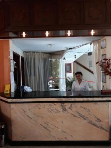 une femme debout derrière un comptoir devant un miroir dans l'établissement Hotel Viru Viru 1, à Santa Cruz de la Sierra