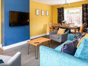 a living room with a blue couch and chairs at Rose Cottage in Skegness