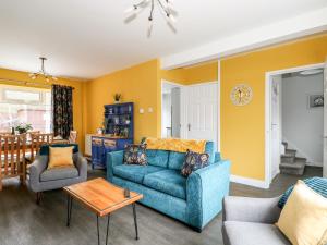 a living room with a blue couch and a table at Rose Cottage in Skegness