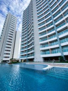 a swimming pool in front of two tall buildings at Fortaleza Sul Flats Service in Fortaleza