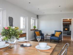 a dining room and living room with a table and chairs at The Elberry in Llanfairpwllgwyngyll
