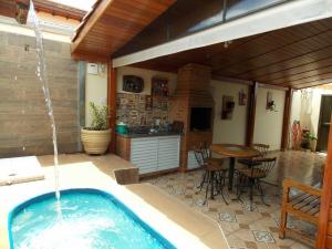 a hot tub in a patio with a table at Chalé aconchegante Brotas SP + Área Rústica privativa + Ar condicionado in Brotas