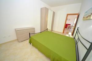 een slaapkamer met een groen bed in een kamer bij VillettaPuce in Corsano