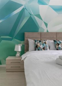 a bedroom with a white bed and a blue wall at Imedio Azure Apartment Aviatiei in Bucharest