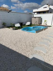 um quintal com uma piscina e um pátio de cascalho em Dos Leones em Vejer de la Frontera