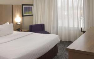 um quarto de hotel com uma cama e uma cadeira azul em Crowne Plaza Cleveland Airport, an IHG Hotel em Middleburg Heights