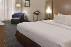 a hotel room with a large bed and a chair at Crowne Plaza Cleveland Airport, an IHG Hotel in Middleburg Heights