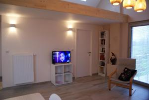 a living room with a tv on a wall at Le gîte de la Reine de Hongrie in Soignies