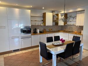 a kitchen with white cabinets and a table with chairs at Ferienhaus Dalmatia in Kali
