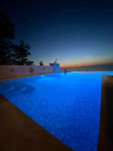 uma piscina à noite com o oceano ao fundo em Resort - Località Santa Barbara em Bagnara Calabra