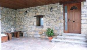 Casa de piedra con puerta de madera y mesa en Casa Rural Tejedor, en Morillo de Monclús