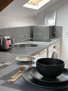 a kitchen with a black bowl on a plate on a counter at Studio Hypercentre - Quartier Gare in Valenciennes