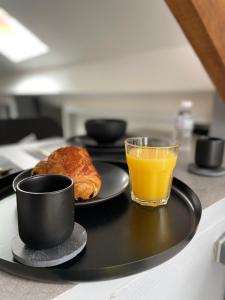 a tray with a plate of food and a glass of orange juice at Studio Hypercentre - Quartier Gare in Valenciennes
