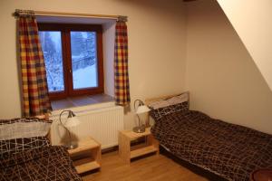 1 dormitorio con 2 camas y ventana en Chalupa U Effoucha, en Lipno nad Vltavou