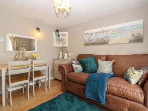 a living room with a couch and a table at Linda Cottage in Ryde