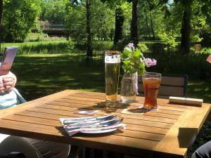 un tavolo di legno con due bicchieri di birra sopra di Landhotel Gutshof im Oertzetal in Oldendorf, Südheide a Hermannsburg