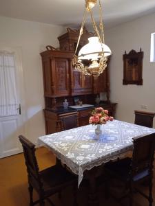 uma sala de jantar com uma mesa e um lustre em Kuća za odmor "Šokačka lady" em Županja