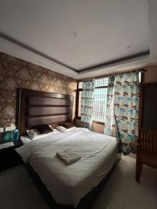 a bedroom with a large bed with two towels on it at Vanu Homestay in Shimla