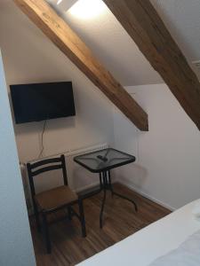 MerenschwandにあるLandgasthof Schwanenのテーブル、椅子、テレビが備わる客室です。