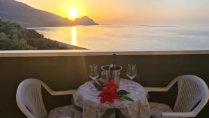 a table with wine glasses and a red flower on it at CH Exclusive Apartments in Cefalù