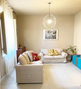 a living room with two couches and a chandelier at Casa Milvio a Marina di Cecina by Zoom In Earth in Marina di Cecina